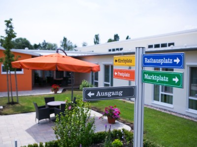 Ein Wegweiser im Seniorenhaus Mühlenpark zeigt verschiedene Richtungen
