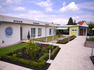 Ein Seniorenhaus mit gepflegtem Garten und Gehweg im Mühlenpark